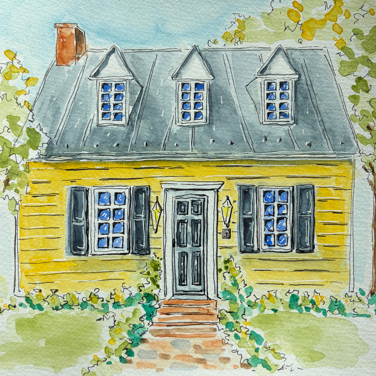 Watercolor and ink painting of a yellow colonial house with three dormers, a gray roof, dark shutters, lanterns and a brick path lined with greenery