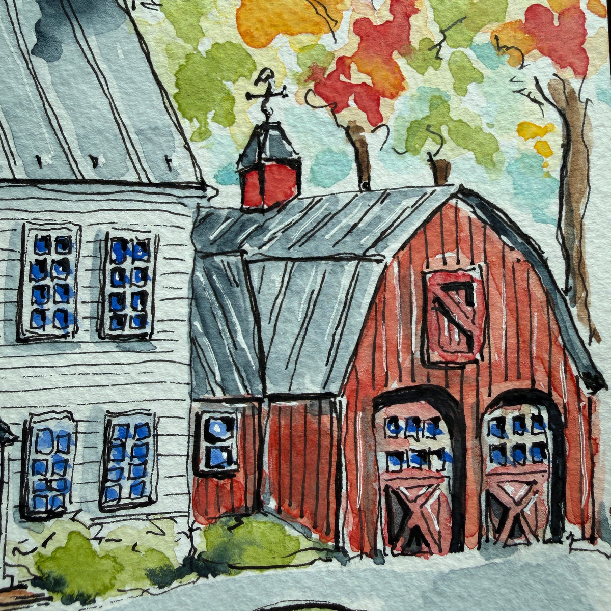 Detail of the red barn with arched doors, cupola, weathervane and fall foliage