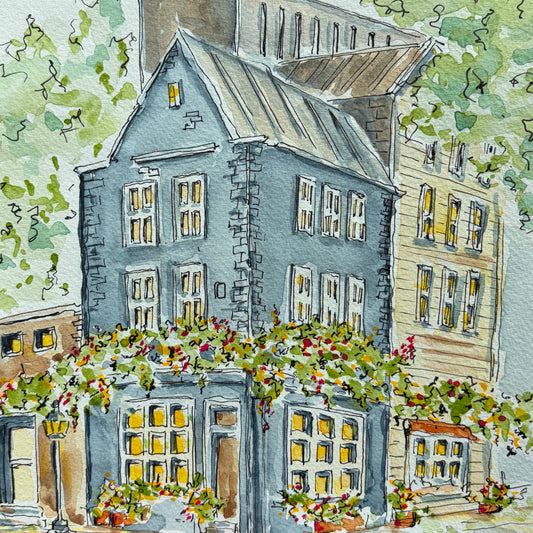Watercolor and ink painting of a blue stone townhouse with glowing yellow windows, a yellow clapboard neighbor, flowering vines and a street lamp