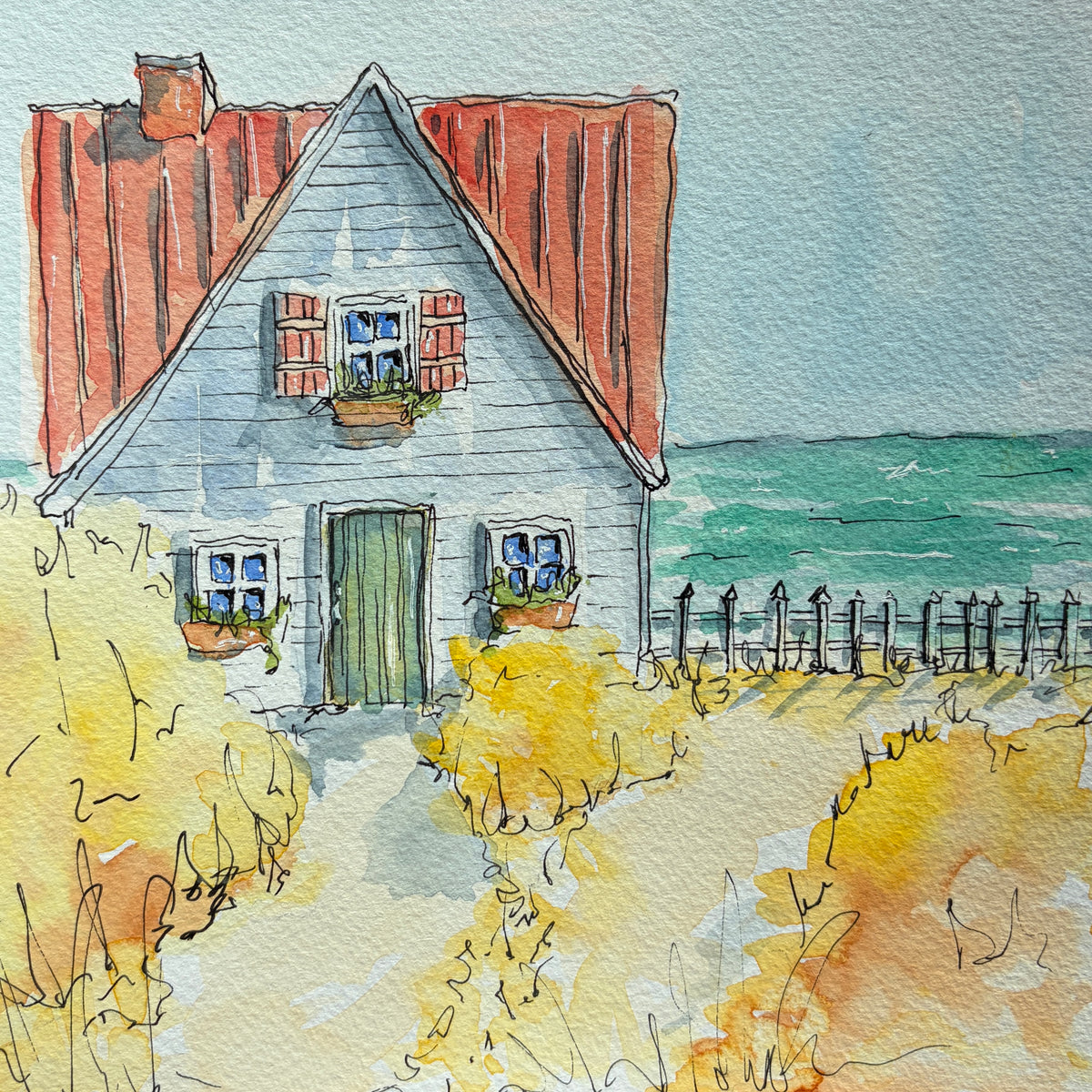Watercolor and ink painting of a gray clapboard cottage with a red roof, green door and window boxes beside a picket fence and turquoise ocean